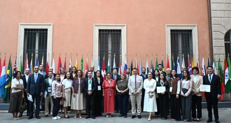 BEPCAC 2026 participants and team at UNIDROIT headquarters in Rome, standing together in front of national flags