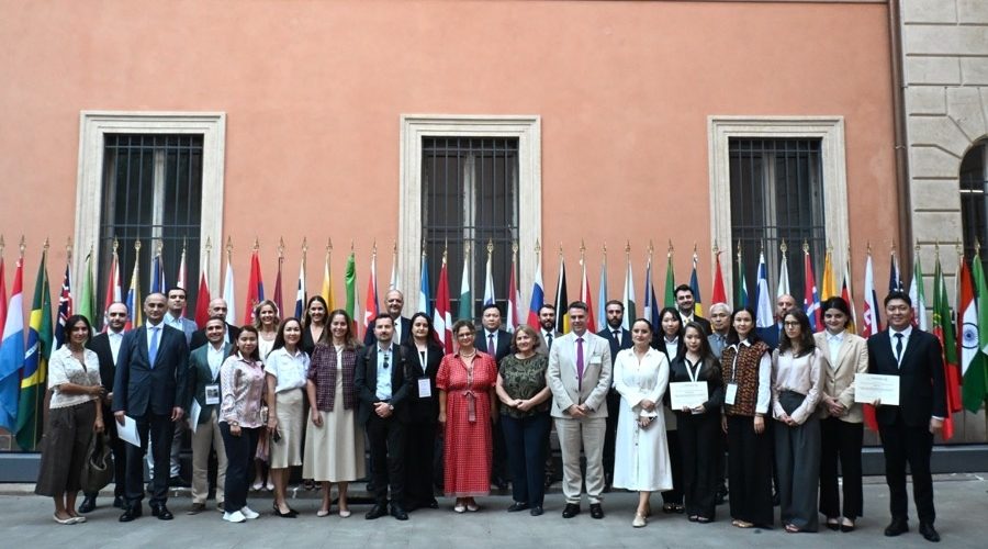 BEPCAC 2026 participants and team at UNIDROIT headquarters in Rome, standing together in front of national flags