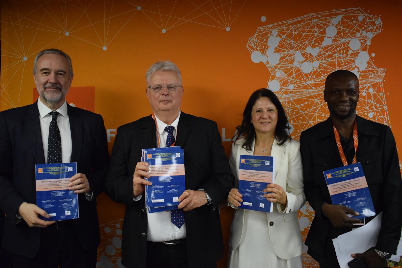 Four participants holding copies of the volume honouring Professor Jan L. Neels.